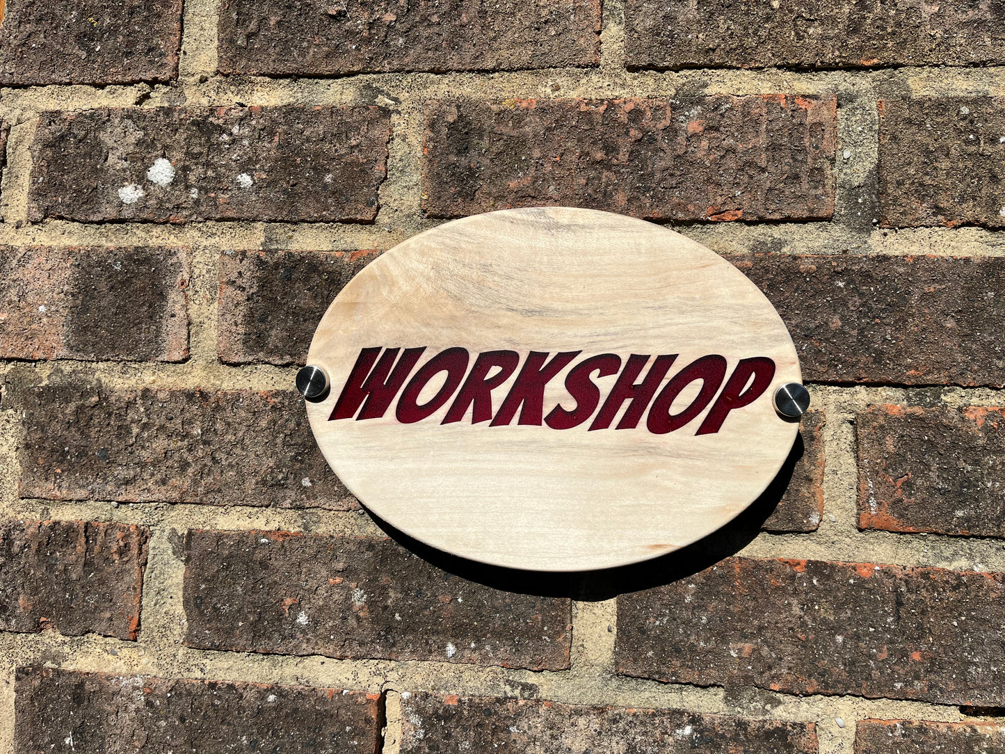 Wooden sign with 'WORKSHOP' text on a brick wall