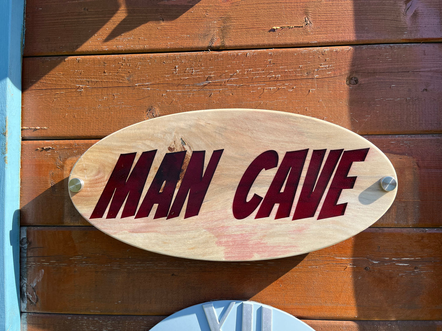 Wooden sign with 'MAN CAVE' text on a wooden background